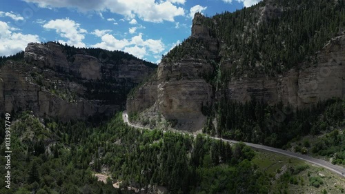 Aerial of winding road by cliff in Colorado mountains. USA.	