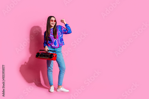 Full size photo of pretty teen girl winning hold boombox sunglass wear trendy colorful outfit isolated on pink color background