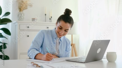 Online lecture. Happy caucasian young woman, student, employer, sits at a work desk with laptop, listening online lesson, takes notes, brainstorming with partners, talking via video call with client