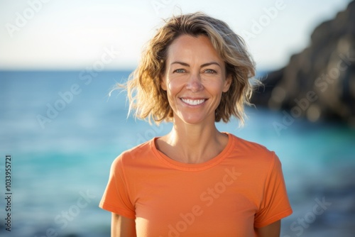 Portrait of a smiling woman in her 40s dressed in a casual t-shirt on tranquil coral reef background