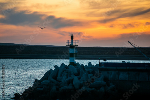 Aatardecer en el Puerto de Camarones, en la Patagonia Argentina, provincia de Chubut, donde se puede apreciar el característico faro.  photo