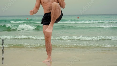 a man does a warm-up, fitness on the seashore, walking on the shore