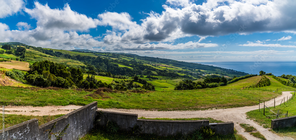Obraz premium A view along the coast from the Chapel of Our Lady of Peace above Ribeira Seca on the island of San Miguel in the Azores in summertime