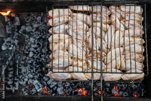 Chiken on the grill against the background of hot coals in the grill - paleo food photography.Delicious chiken steak, hot barbecue grill.Roasted chiken leg Grilled, BBQ. Barbecue, picnic in nature photo