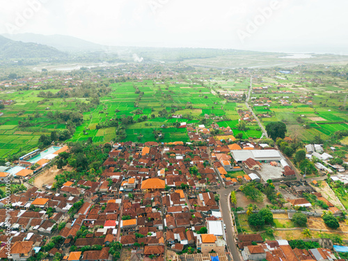 Aerial drone view of Muslim Balinese settlements near green paddy fields scenery at Gelgel Village in Klungkung, Bali, Indonesia. photo