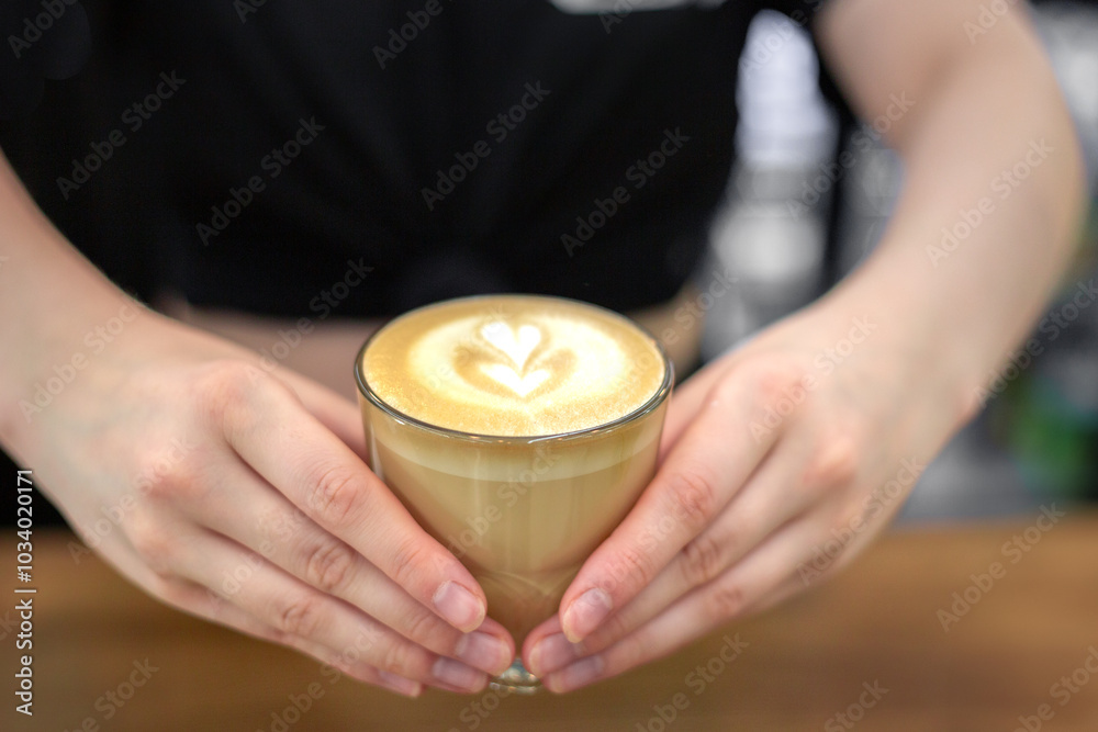 The barista holds a cup of coffee in his hands. Hands and coffee close-up. The barista holds a cup of coffee in his hands. Hands and coffee close-up.