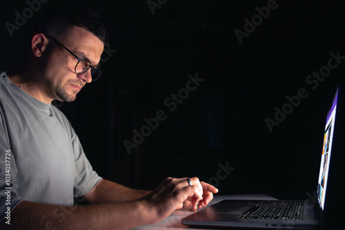 Young man works at the computer at night. photo