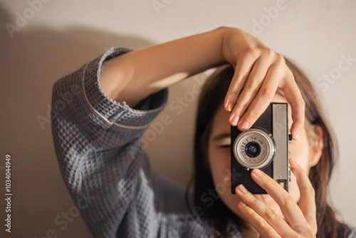 Young woman with a vintage camera. The girl takes pictures on a film camera.