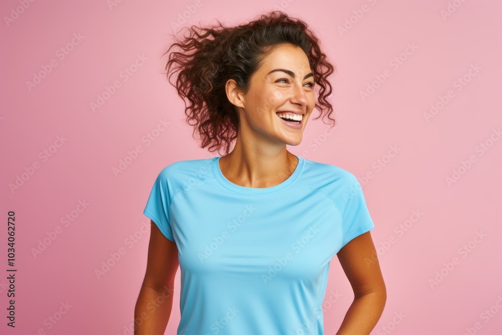 Portrait of a cheerful woman in her 30s wearing a moisture-wicking running shirt isolated on pastel or soft colors background Portrait of a cheerful woman in her 30s wearing a moisture-wicking running shirt isolated on pastel or soft colors background