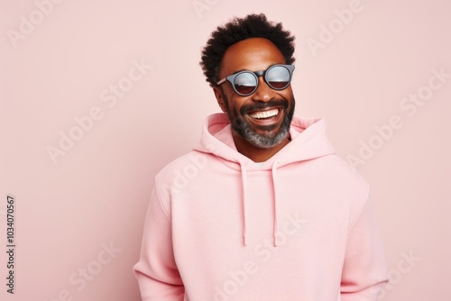 Portrait of a joyful afro-american man in his 40s wearing a thermal fleece pullover over pastel or soft colors background