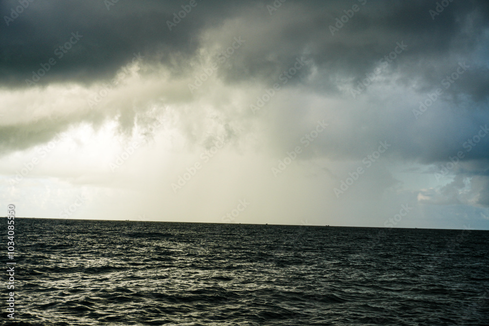 Stormy seascape with dark clouds and crashing waves under a dramatic sunset Stormy seascape with dark clouds and crashing waves under a dramatic sunset