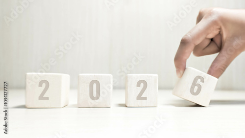 Happy new year 2026. Hands moving wooden blocks for the concept of moving towards 2026. New year 2026 concept with luxurious white wooden blocks