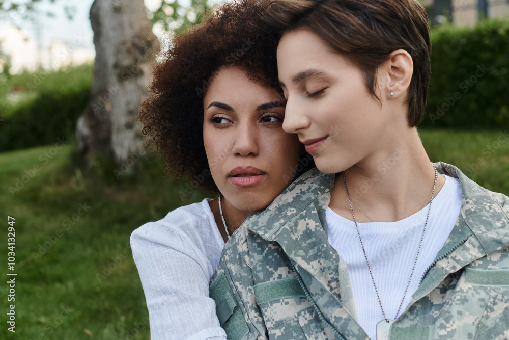 Fototapeta premium A joyful reunion as a soldier is warmly embraced by her loving wife on returning home.