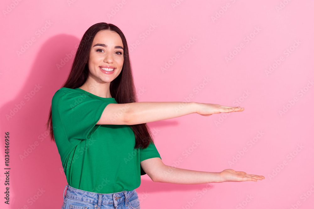 Photo of shiny attractive lady dressed green t-shirt holding arms empty space isolated pink color background Photo of shiny attractive lady dressed green t-shirt holding arms empty space isolated pink color background