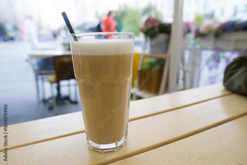 Cappuccino in a glass glass with a straw. Morning hot invigorating drink Cappuccino in a glass glass with a straw. Morning hot invigorating drink