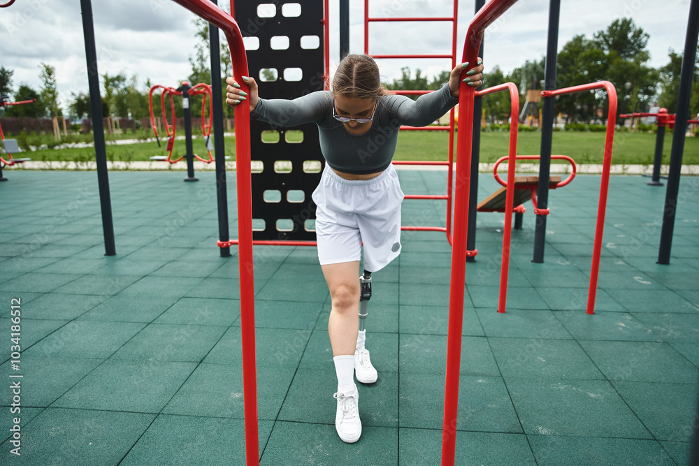 Fototapeta premium A young woman with a prosthetic leg confidently trains outdoors, showcasing her strength and determination.