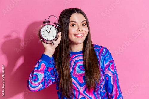 Photo portrait of pretty teen girl hold clock timer wear trendy colorful outfit isolated on pink color background