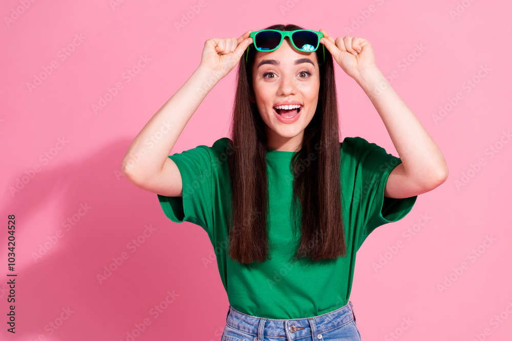 Photo of impressed attractive lady dressed green t-shirt dark eyewear empty space isolated pink color background Photo of impressed attractive lady dressed green t-shirt dark eyewear empty space isolated pink color background