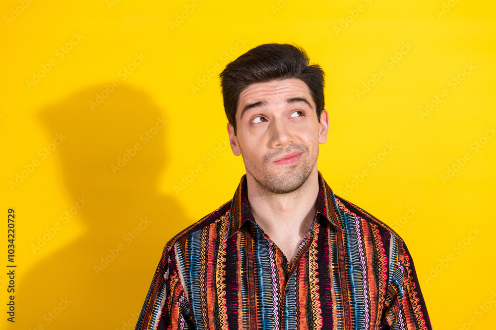 Portrait of nice young man look empty space wear shirt isolated on yellow color background Portrait of nice young man look empty space wear shirt isolated on yellow color background