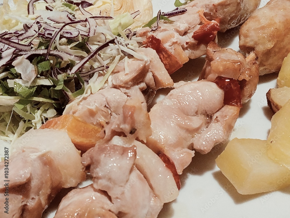 Italian dish with meat skewers, salad and baked potatoes
