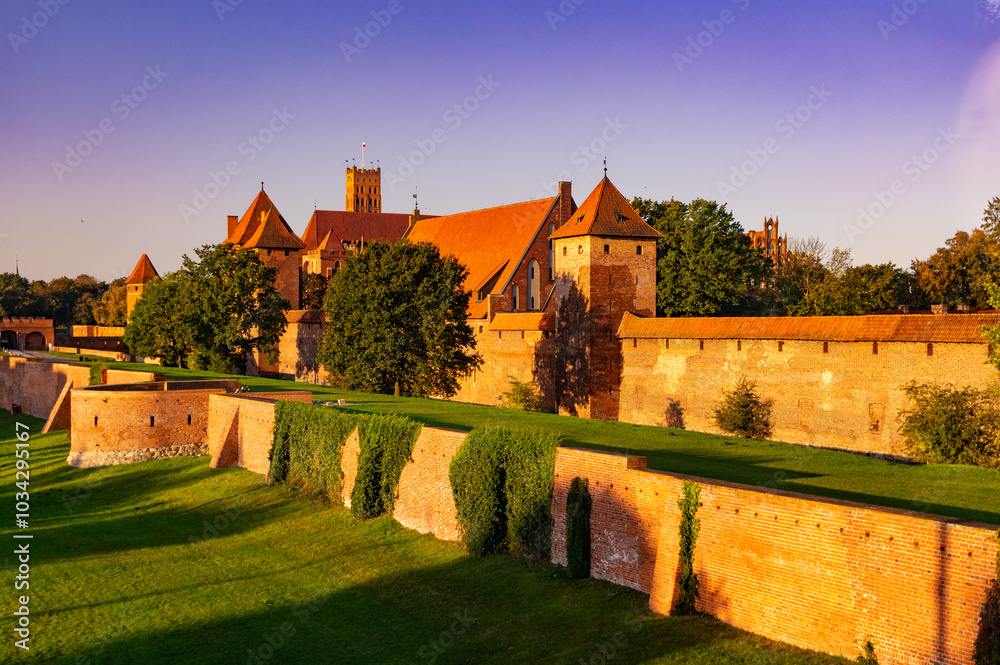 Naklejka premium Medieval gothic Malbork Castle at sunrise