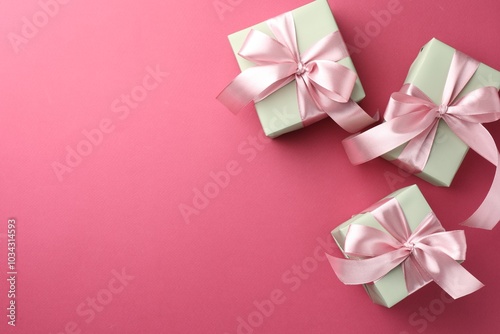 Beautiful gift boxes with bows on pink background, flat lay. Space for text