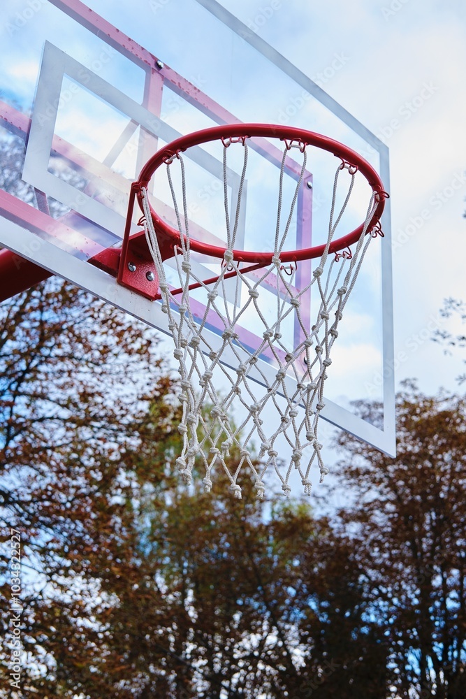 Red basketball hoop with white net in city park. Outdoor active games. Red basketball hoop with white net in city park. Outdoor active games.