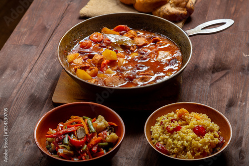 Hot thick cholent in a cast iron pan on the festive table for the meal on Rosh Hashanah