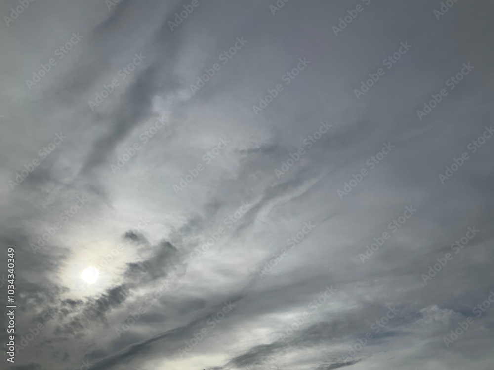 Fototapeta premium Cloudy sky with grey clouds and sun - natural background. Topics: weather, meteorology, atmosphere, air space, season