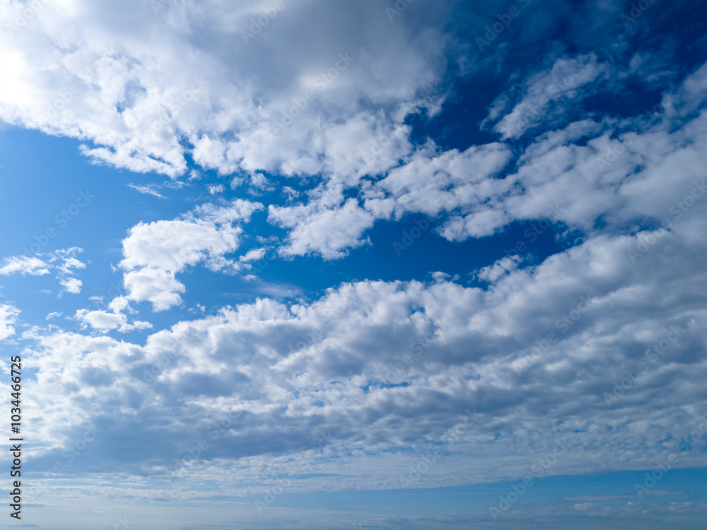 A beautiful sky full of fluffy clouds against a vibrant blue background, ideal for nature themes. A beautiful sky full of fluffy clouds against a vibrant blue background, ideal for nature themes.
