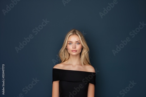 Blonde Woman with Long Hair, Black Off-Shoulder Top, Soft Makeup, Dark Blue Background, Clear Skin, Minimalist Style, Feminine Elegance, Modern Fashion, Copyspace for Text

