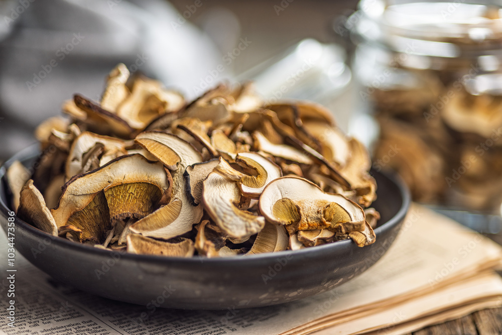 Dried porcini mushrooms. Sliced boletus on plate on wooden table. Dried porcini mushrooms. Sliced boletus on plate on wooden table.