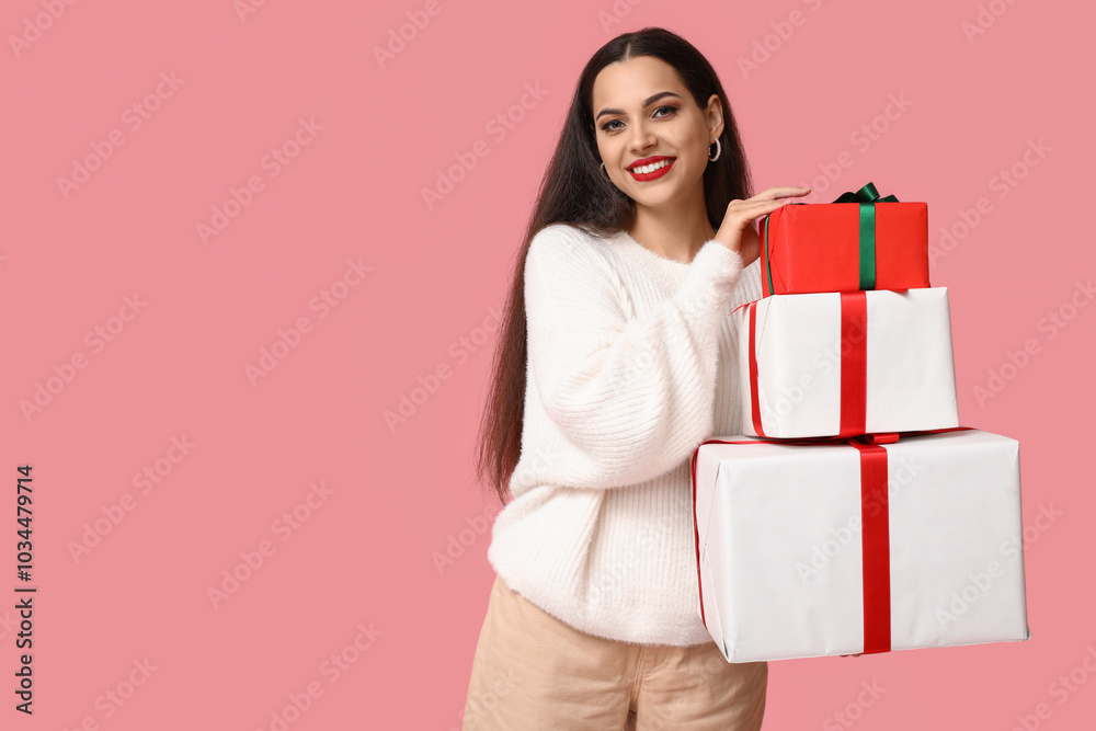 Beautiful young woman with Christmas gifts on pink background Beautiful young woman with Christmas gifts on pink background