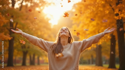 A smiling woman with outstretched arms enjoys the vibrant fall foliage in a sunny park setting, embodying happiness and freedom.