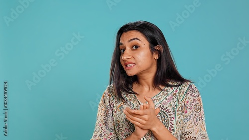 Portrait of jealous indian woman mockingly clapping hands, isolated over studio background. Annoyed person rolling eyes and applauding in jest, doing fake cheering, camera B photo