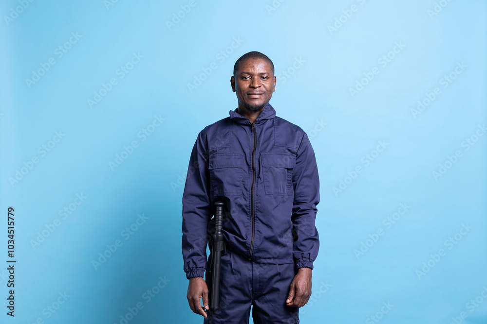 African american security agent safeguarding the perimeter in front of the camera, dressed in uniform with baton. Male defense personnel working on property protection, patrol service.