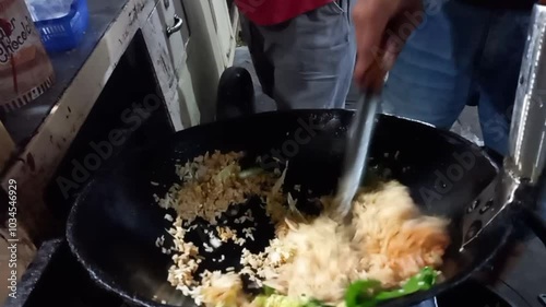 Fried rice. The chef is frying rice on a hot frying pan. prepare customer orders. Close up.