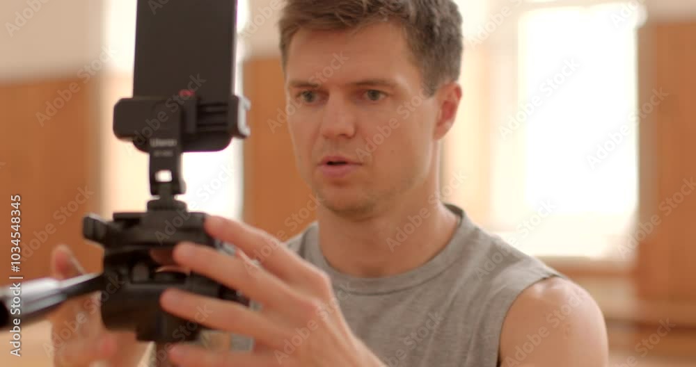 man focused using smartphone camera equipment indoor filming modern studio, showing dedication task Ready to broadcast man focused using smartphone camera equipment indoor filming modern studio, showing dedication task Ready to broadcast