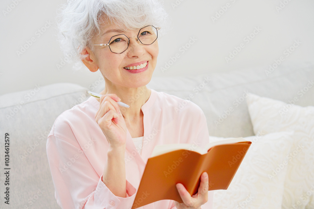 笑顔でスケジュール帳を持つシニア女性