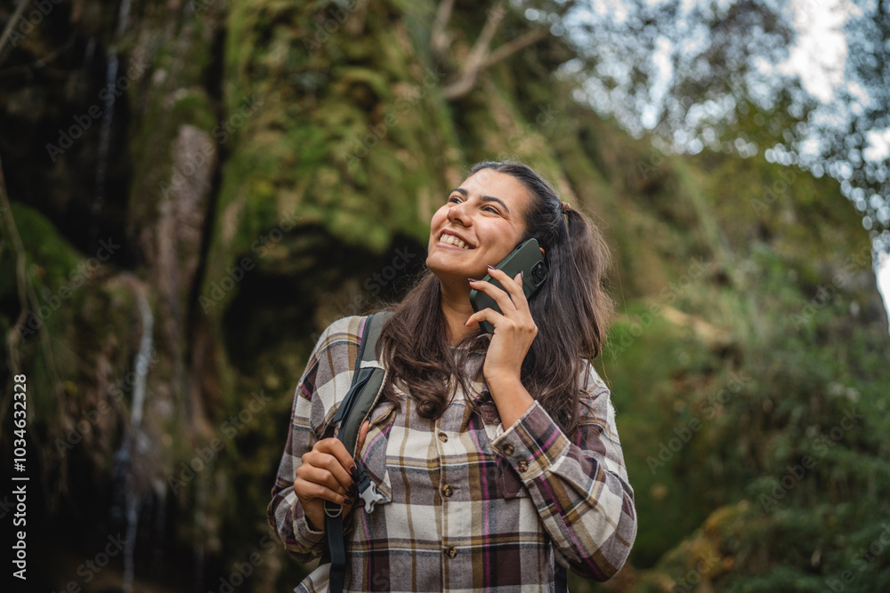 Beautiful woman hiker backpacker use mobile phone around waterfall Beautiful woman hiker backpacker use mobile phone around waterfall
