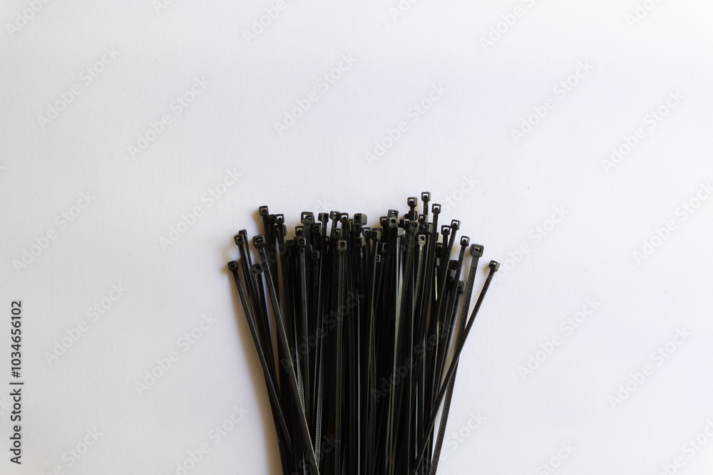 Black plastic cable ties with various layouts isolated on white background. Black plastic cable ties with various layouts isolated on white background.