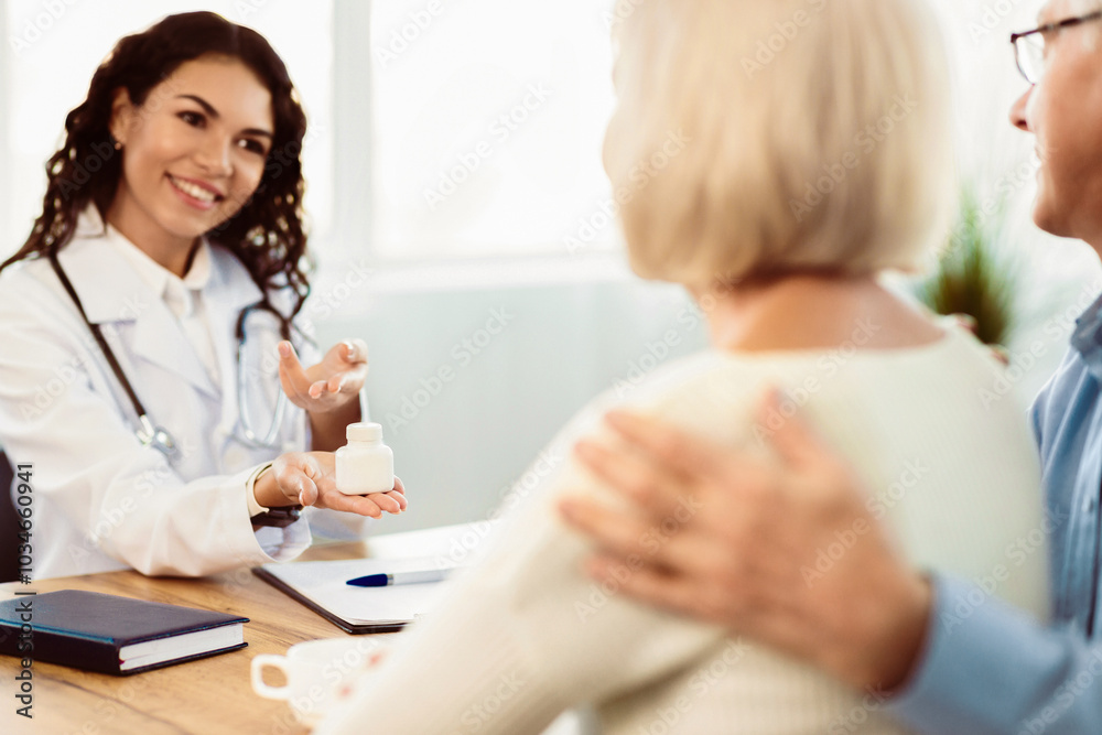 Healthcare Concept. Hispanic doctor showing pills to her mature patients, senior couple listening, empty space Healthcare Concept. Hispanic doctor showing pills to her mature patients, senior couple listening, empty space