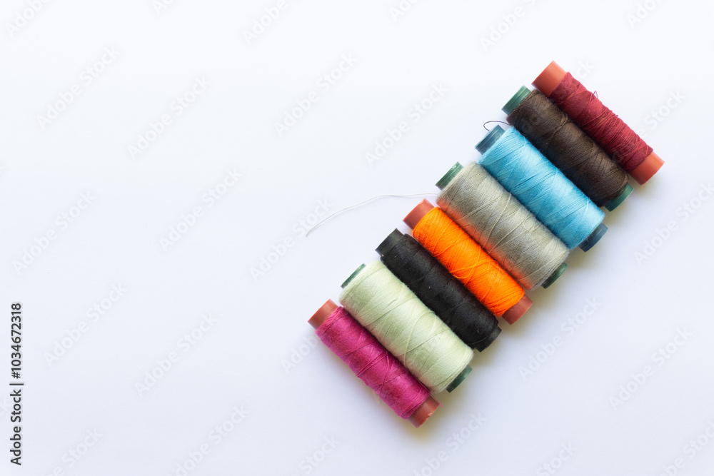 Top view of colorful threads on white background with various layouts. Top view of colorful threads on white background with various layouts.