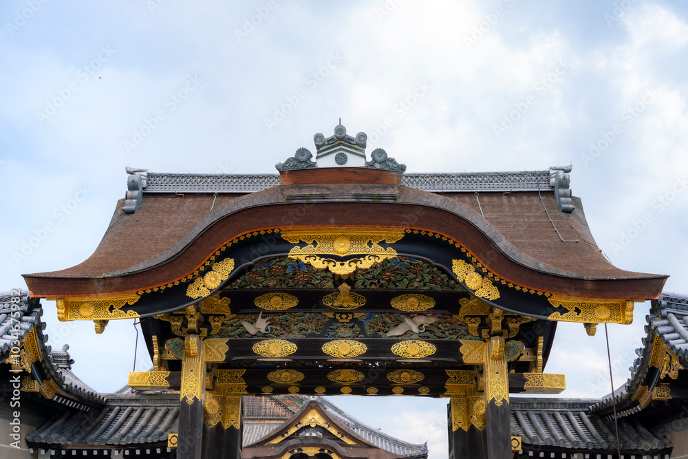 A close-up view of the beautifully ornate entrance gate at Nijo Castle in Kyoto, Japan. The gate features intricate gold details and traditional Japanese architectural designs, showcasing the castle's A close-up view of the beautifully ornate entrance gate at Nijo Castle in Kyoto, Japan. The gate features intricate gold details and traditional Japanese architectural designs, showcasing the castle's