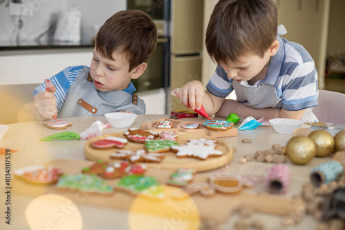 Happy family mother and children in aprons making Christmas cookies together while cooking 