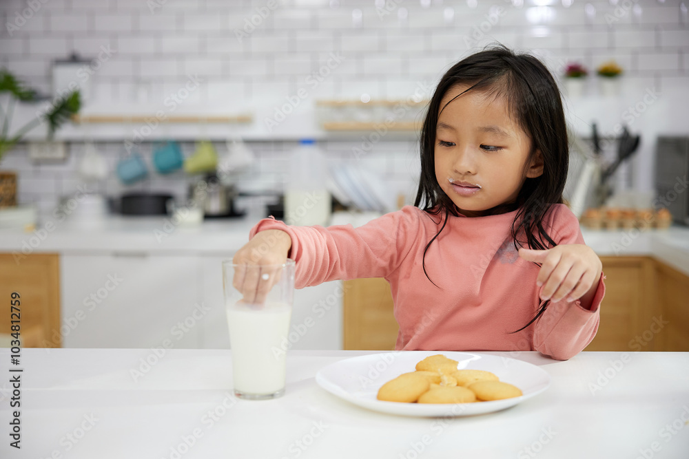 Portrait child girl enjoy eating cookies and drinking milk in the kitchen Portrait child girl enjoy eating cookies and drinking milk in the kitchen