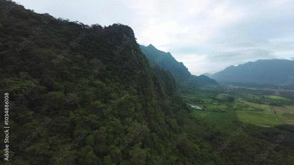 Aerial drone high above Blue Lagoon in Laos, capturing rolling hills, dense jungle, and serene water reflections Aerial drone high above Blue Lagoon in Laos, capturing rolling hills, dense jungle, and serene water reflections