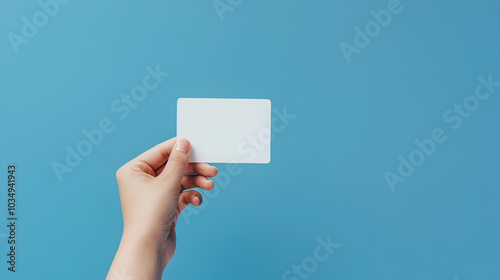 hand holding a blank credit chip card on a blue background photo