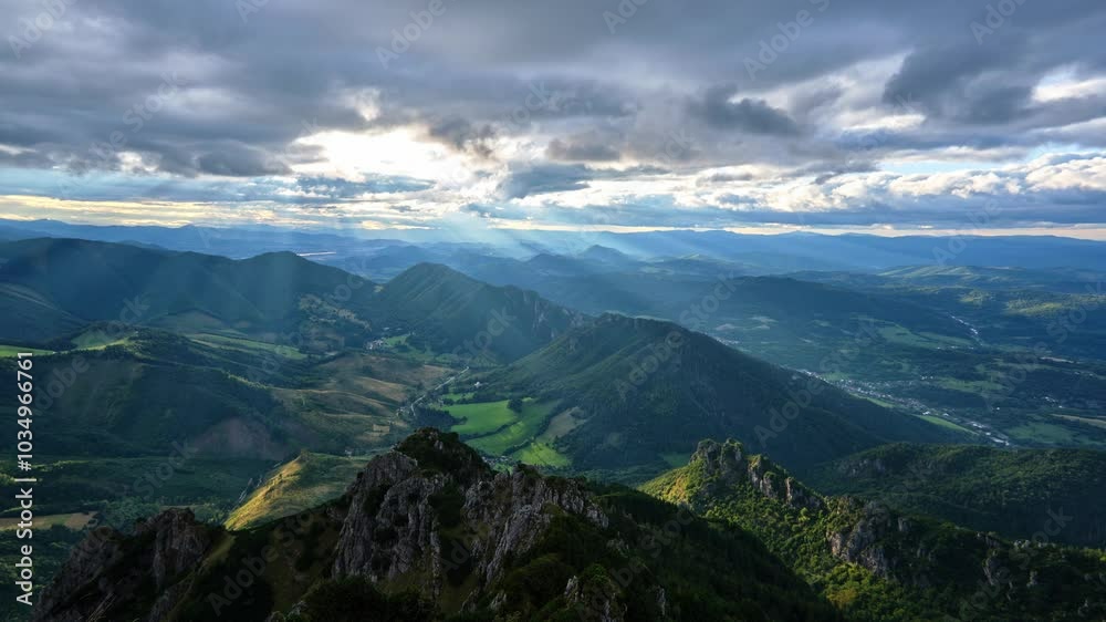 Sunbeams shine through moving clouds at sunset. Rays illuminate the idyllic hilly landscape in carpathians Sunbeams shine through moving clouds at sunset. Rays illuminate the idyllic hilly landscape in carpathians