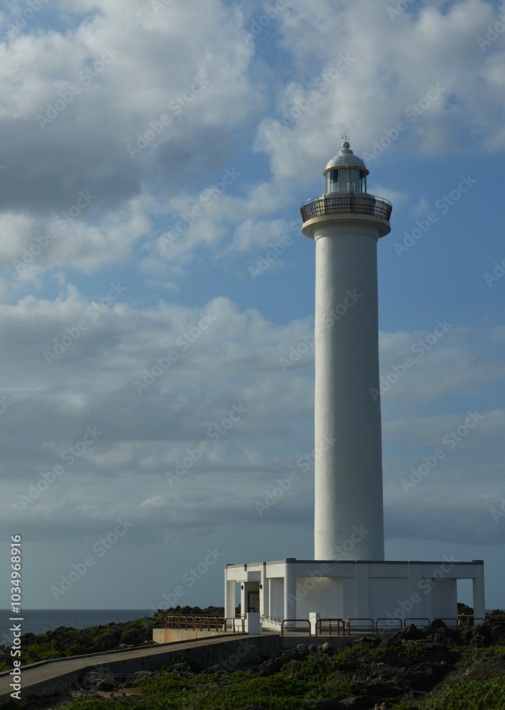 A lighthouse standing proudly on the shore, bathed in beautiful weather A lighthouse standing proudly on the shore, bathed in beautiful weather